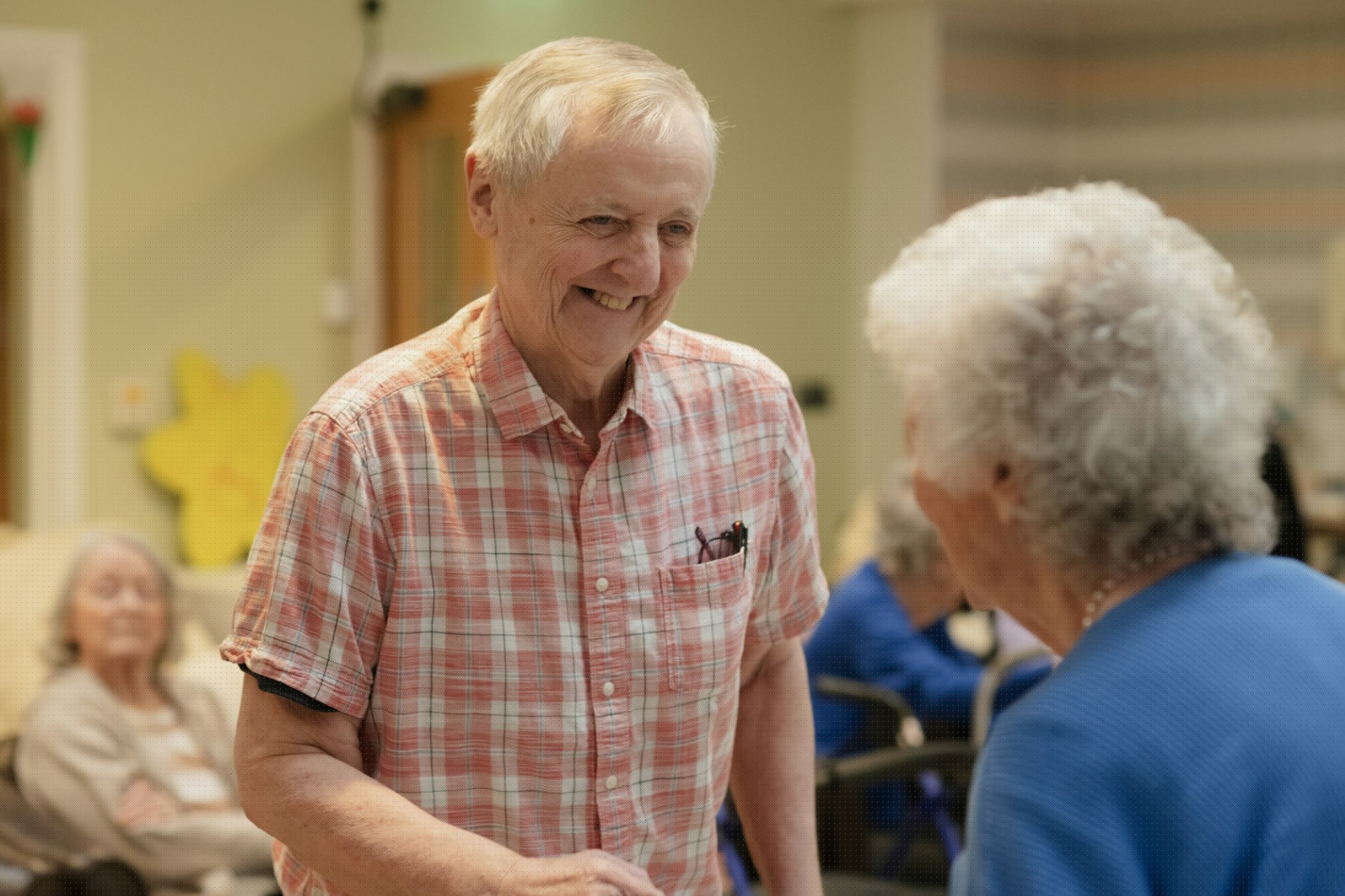 Two people smiling and conversing warmly together at home